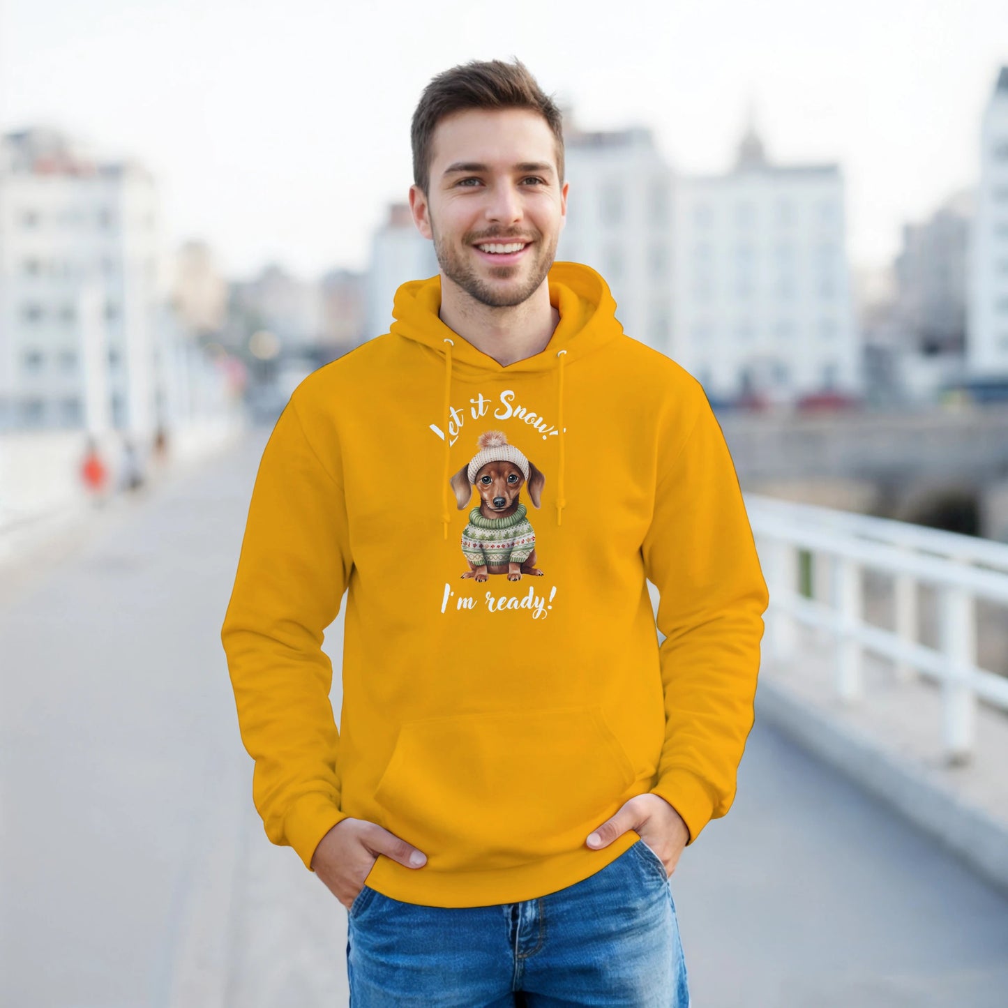Man wearing a mustard yellow hoodie with a dog graphic and text, standing on a bridge.