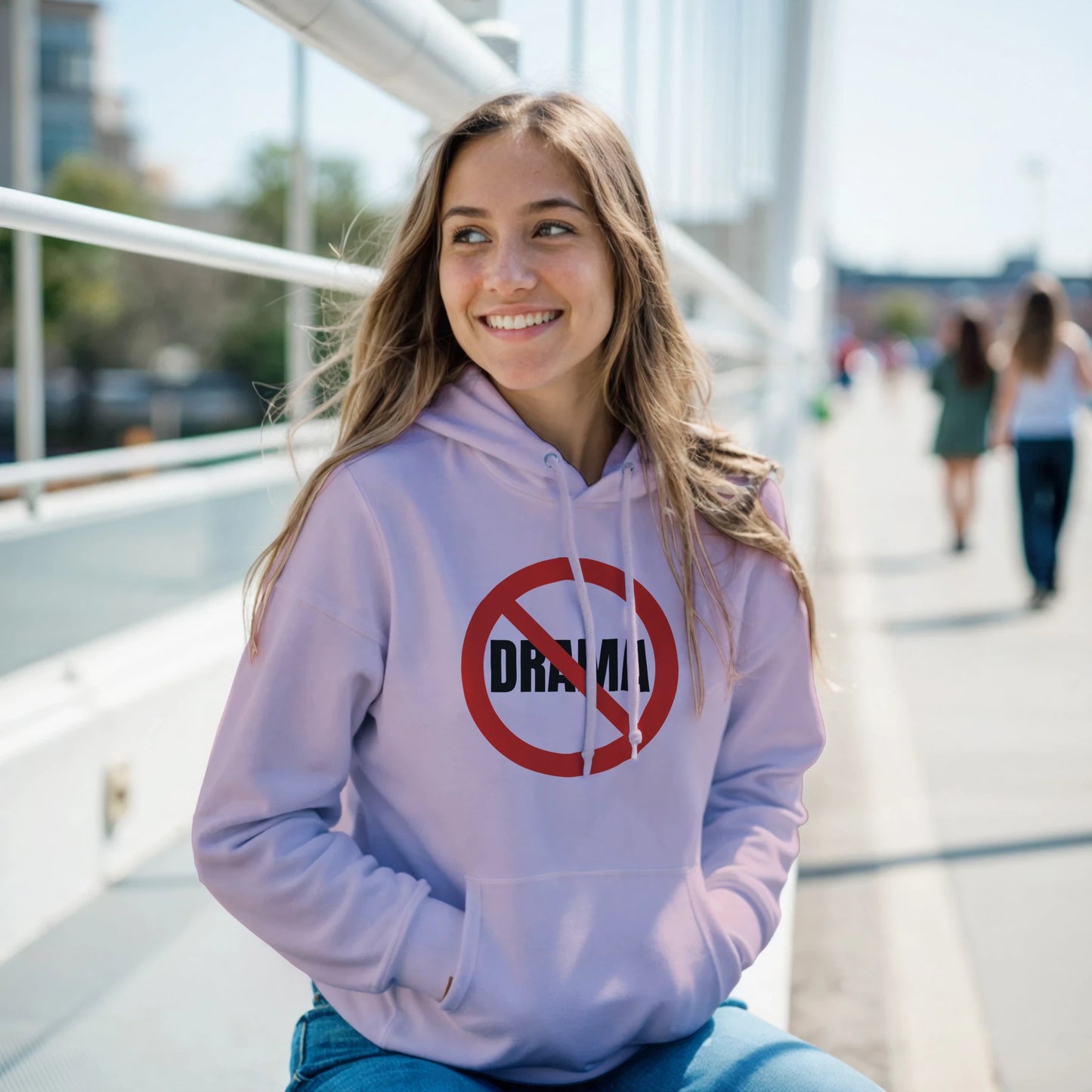 Woman wearing a light pink hoodie with a 'No Drama' symbol 
