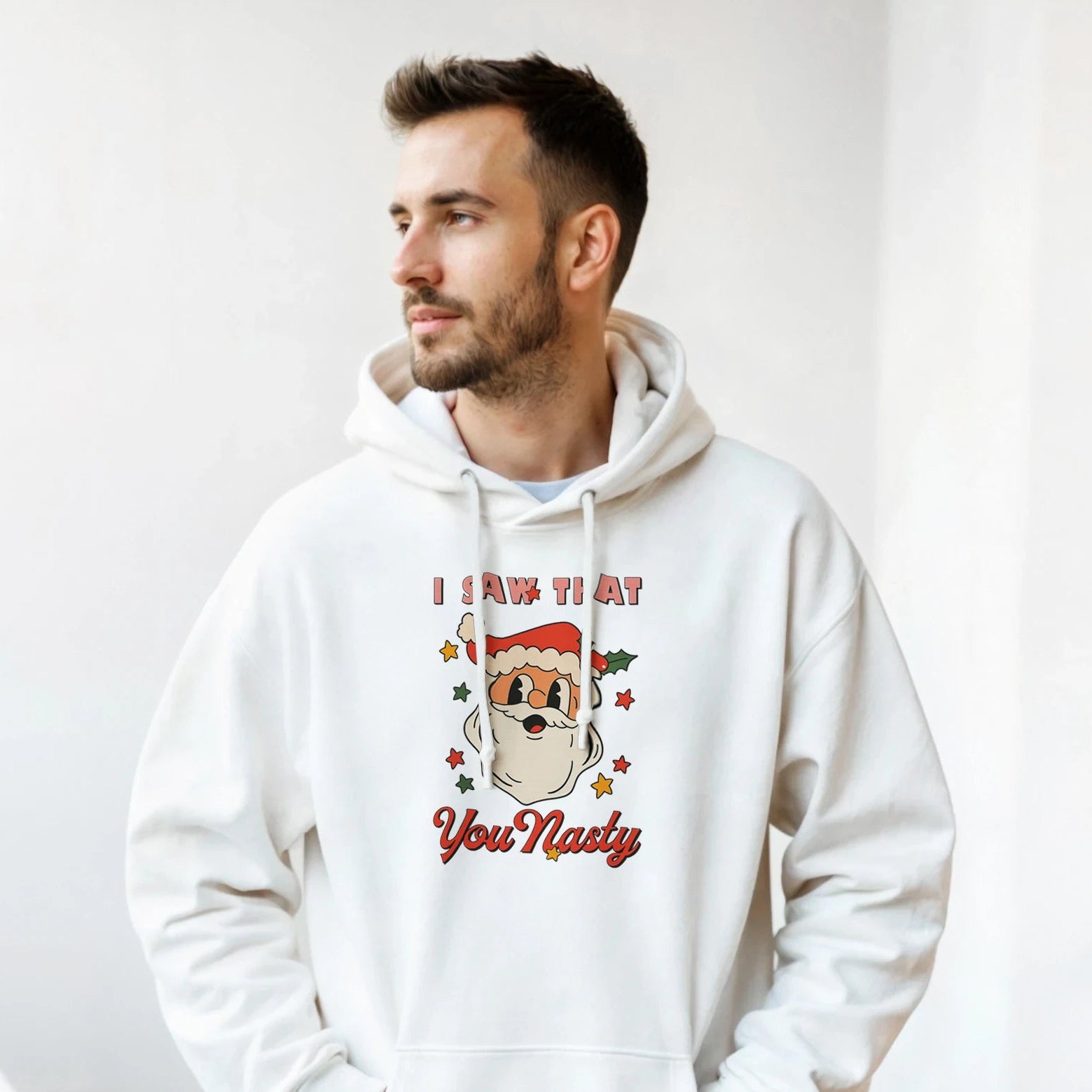 Man wearing a white hoodie with a Christmas-themed design indoors.